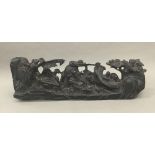 A Chinese hardwood carving Formed as a reclining deity holding a ruyi sceptre surrounded by