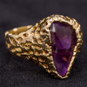 A contemporary unmarked gold ring Of pierced form, set with an amethyst. 2 cm high.