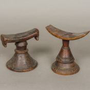 An African tribal carved wooden headrest Of typical curved form above the turned and carved conical