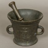 A 17th century bronze twin handled mortar with double ended pestle Decorated with opposing