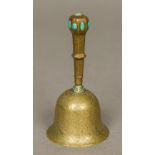 A 19th century Persian brass hand bell With engraved scrolling floral designs and set with