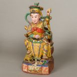 A Chinese painted carved wooden deity Modelled seated with a cow and a snake at his feet. 40.