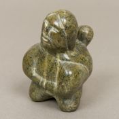 An Inuit carved hardstone figure Worked as a mother carrying her child. 10 cm high.