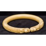 A 19th century ivory bangle Carved with two mermaids. 8.5 cm wide.