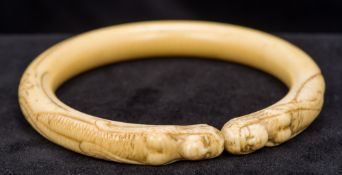 A 19th century ivory bangle Carved with two mermaids. 8.5 cm wide.