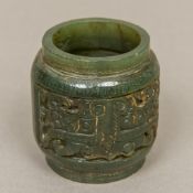 A Chinese carved spinach jade roundel Of lobed form, with twin carved panels. 6 cm high.