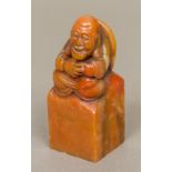 A Chinese carved soapstone seal The top formed as a seated figure;