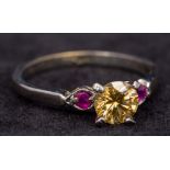 A 10 ct white gold yellow diamond and ruby ring The central yellow diamond approximately 0.