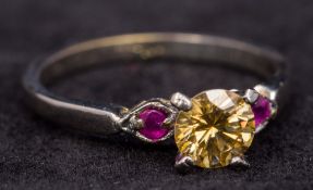 A 10 ct white gold yellow diamond and ruby ring The central yellow diamond approximately 0.