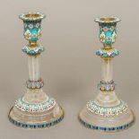 A pair of enamel decorated silver and rock crystal candlesticks Each with removable drip-pan above