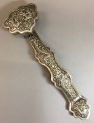 A Chinese white metal ruyi sceptre Typically worked with dragons chasing a flaming pearl.