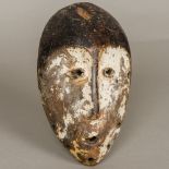 An African tribal carved wooden mask With traces of original lime pigment. 24 cm high.