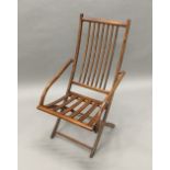 A 19th century stained beech folding deck chair The spindle set back issuing twin sloping open arms