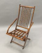 A 19th century stained beech folding deck chair The spindle set back issuing twin sloping open arms