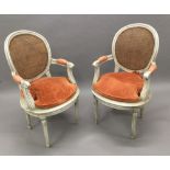 A pair of late 19th/early 20th century caned painted open armchairs Each shaped moulded caned oval