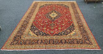 A Kashan wool carpet The wine red field with central medallion with pendant palmettes within