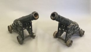 A pair of Victorian cast iron lawn/signal cannons Each barrel supported on a pierced carriage with