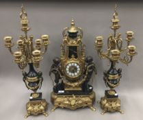 A gilt metal and bronze triple clock garniture