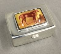 A silver pill box depicting a horse
