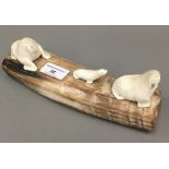 A carved whales tooth walrus family,