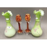 A pair of Victorian florally decorated green satin glass ewers and a pair of glass vases