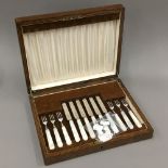 A set of fruit knives and forks, six knives and six forks with hallmarked silver blades and prongs,