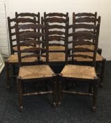 A set of eight rush seated ladder back dining chairs