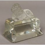 A moulded and cut glass desk weight, worked as a lion recumbent on a plinth. 9.5 cm high.