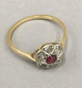 A diamond and ruby flower head ring (1.