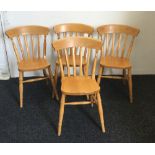 A set of four modern pine splat back kitchen chairs