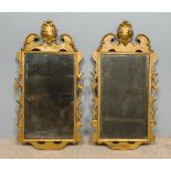 A pair of 18th century gilt framed wall glasses Each with broken swan-neck pediment centred with a
