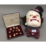 A plaster clown's mask and a set of eleven portrait brooches