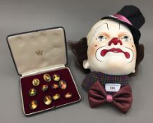 A plaster clown's mask and a set of eleven portrait brooches