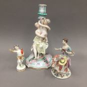 Two 19th century Continental porcelain figurines and a figural candlestick