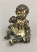 A small cold painted bronze model of a baby