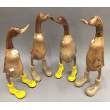 A set of four wooden ducks in boots