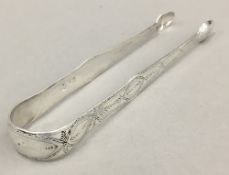 A pair of Georgian silver tongs with acorn bowls