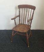 A Victorian stick back solid seated open armchair