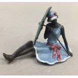 A cold painted bronze figure of a girl holding an umbrella