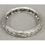 An unmarked white gold, possibly 18 ct, diamond eternity ring, hand engraved (2.