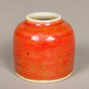 A Chinese porcelain brush wash Of beehive form, with allover mottled iron red glaze. 5.5 cm high.
