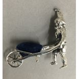 A silver model of a gnome and wheelbarrow