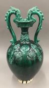 A green drip glazed pottery twin handled vase