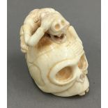 A bone netsuke formed as a skull