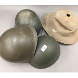 Four vintage military helmets