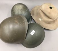 Four vintage military helmets