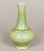 A Chinese porcelain vase, with allover celadon glaze and moulded band decoration. 16 cm high.