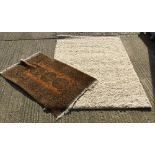 A large modern white ground rug and another