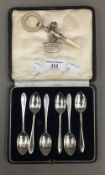 A cased set of silver teaspoons and a silver baby's rattle