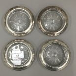 A set of four sterling silver and glass coasters